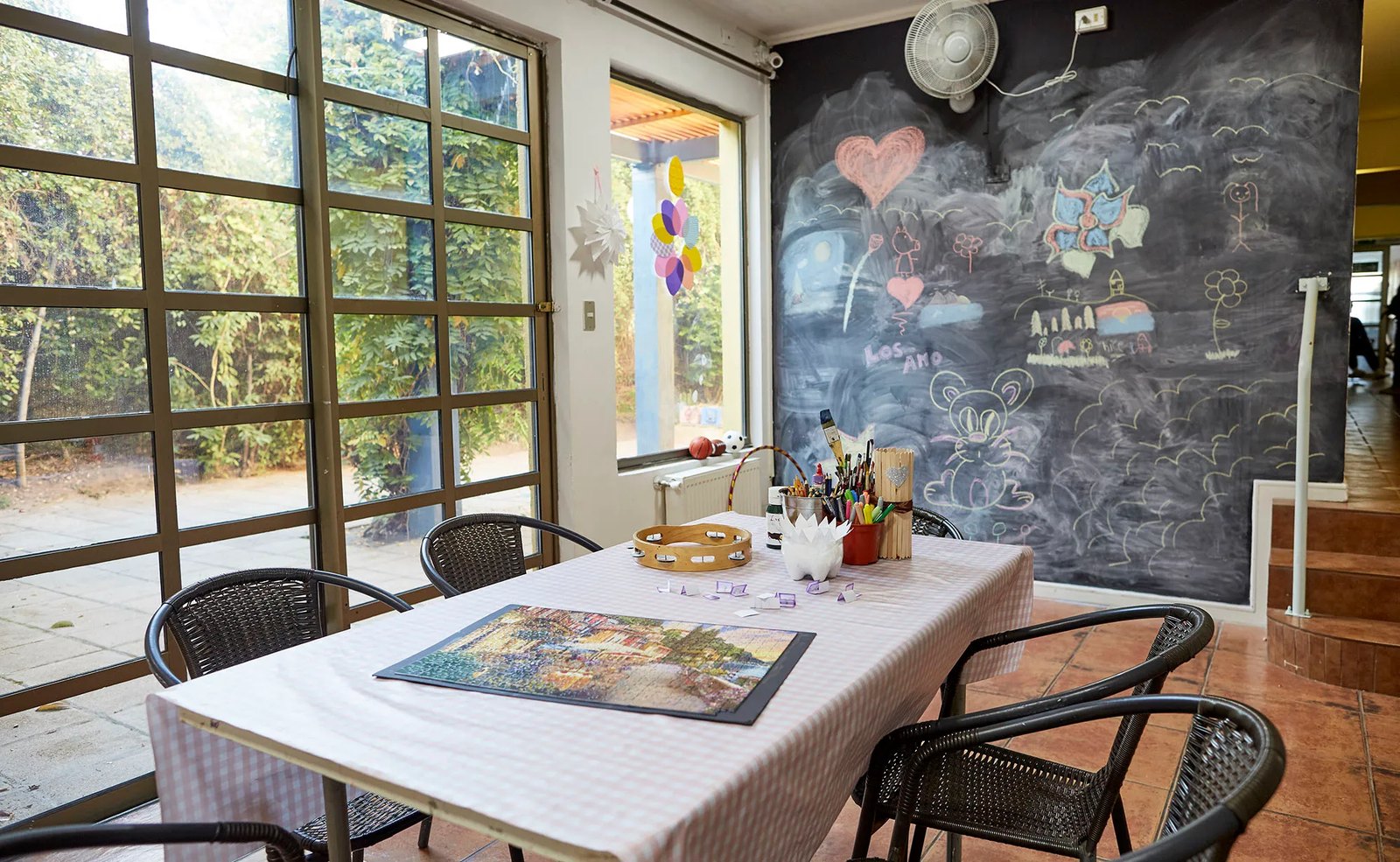 Sala de taller de arte de Clínica Los Tiempos con materiales sobre la mesa